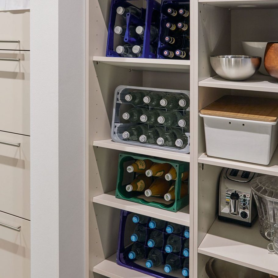 Regal mit verschiedenen Getränkekisten, Gläsern und Küchengeräten.