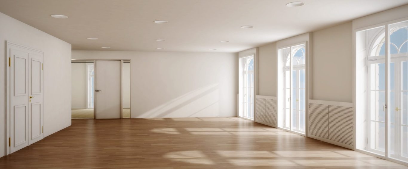 Helles, leeres Zimmer mit Holzfußboden und großen Fenstern.