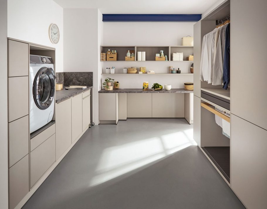 Moderner Hauswirtschaftsraum mit Waschmaschine und Arbeitsfläche sowie Kleiderstangen